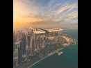 Qatar plane flying over a city during the day
